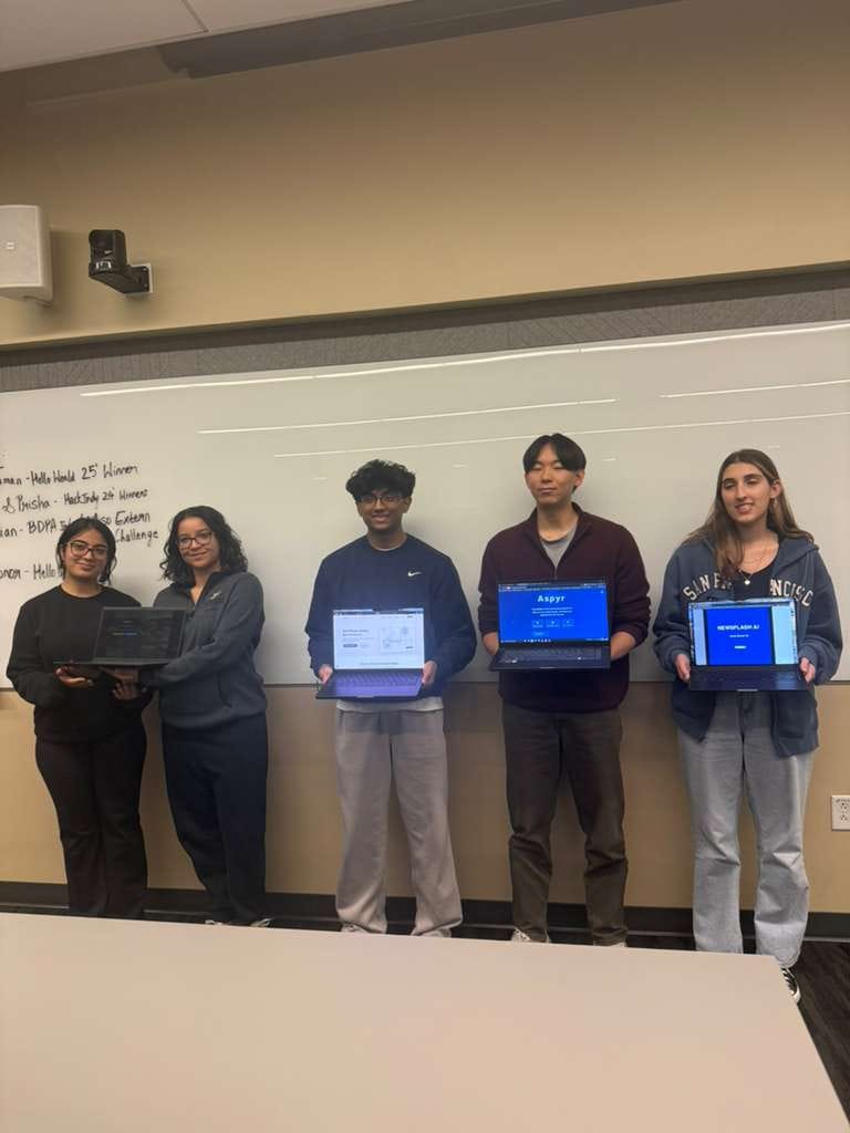Members showing off hackathon-winning projects on their laptops