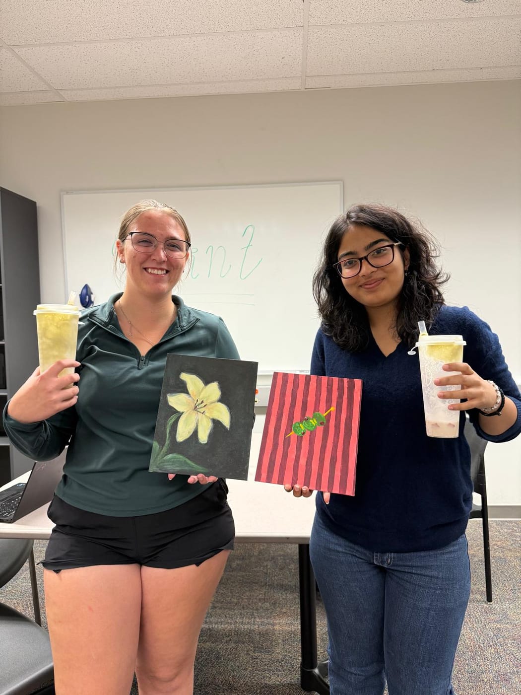 Members with the canvases they painted at a paint-and-sip social